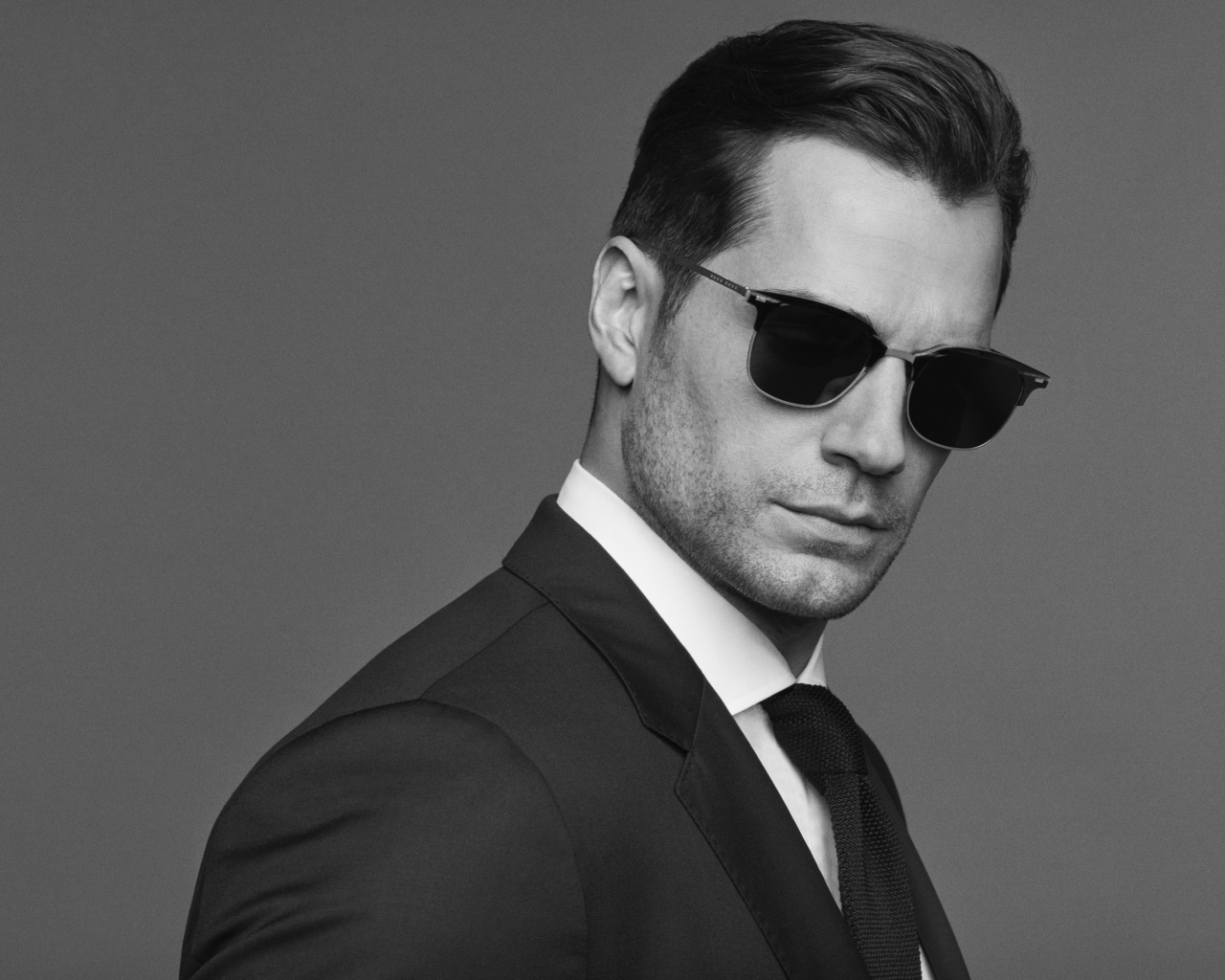 Английский актер Генри Кавилл в черных очках, черно белое фото 