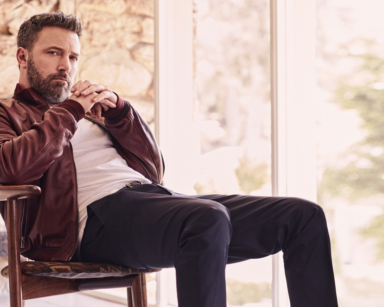 Популярный актер Бен Аффлек сидит на стуле