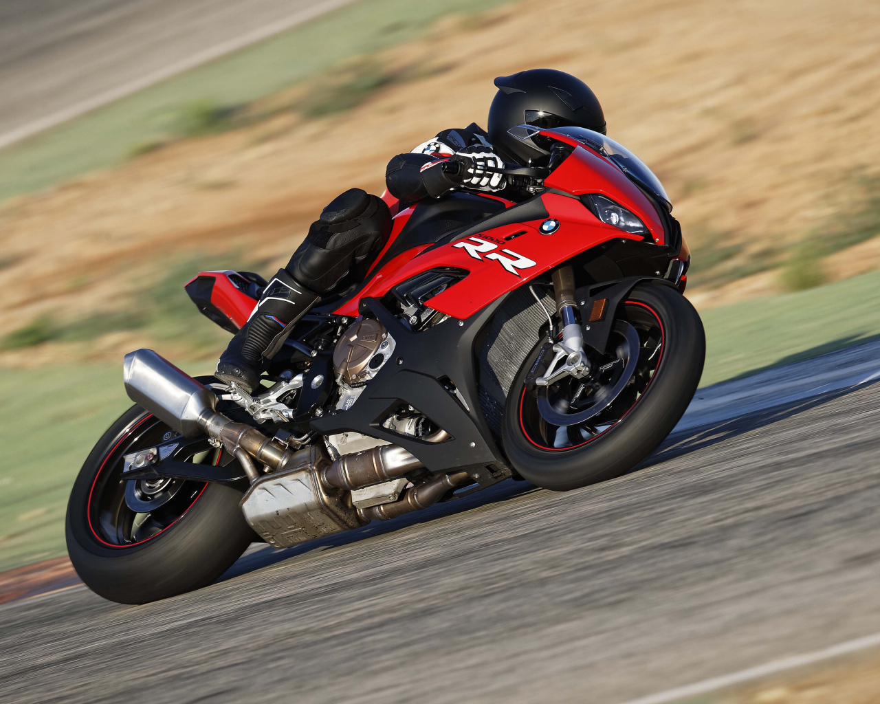 Гонщик на мотоцикле BMW S1000 совершает крутой поворот