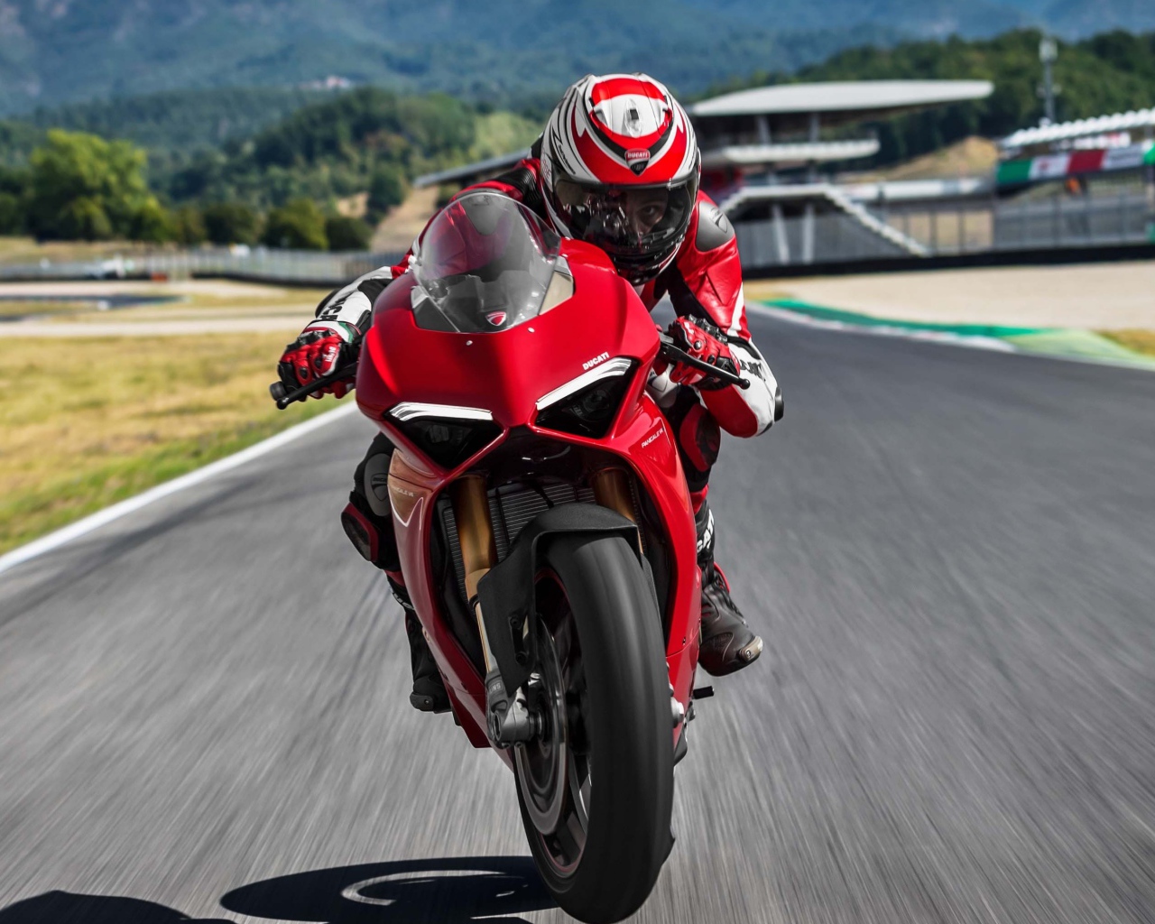 Красный мотоцикл  Ducati Panigale V4 S, 2018 на трассе с мотогонщиком