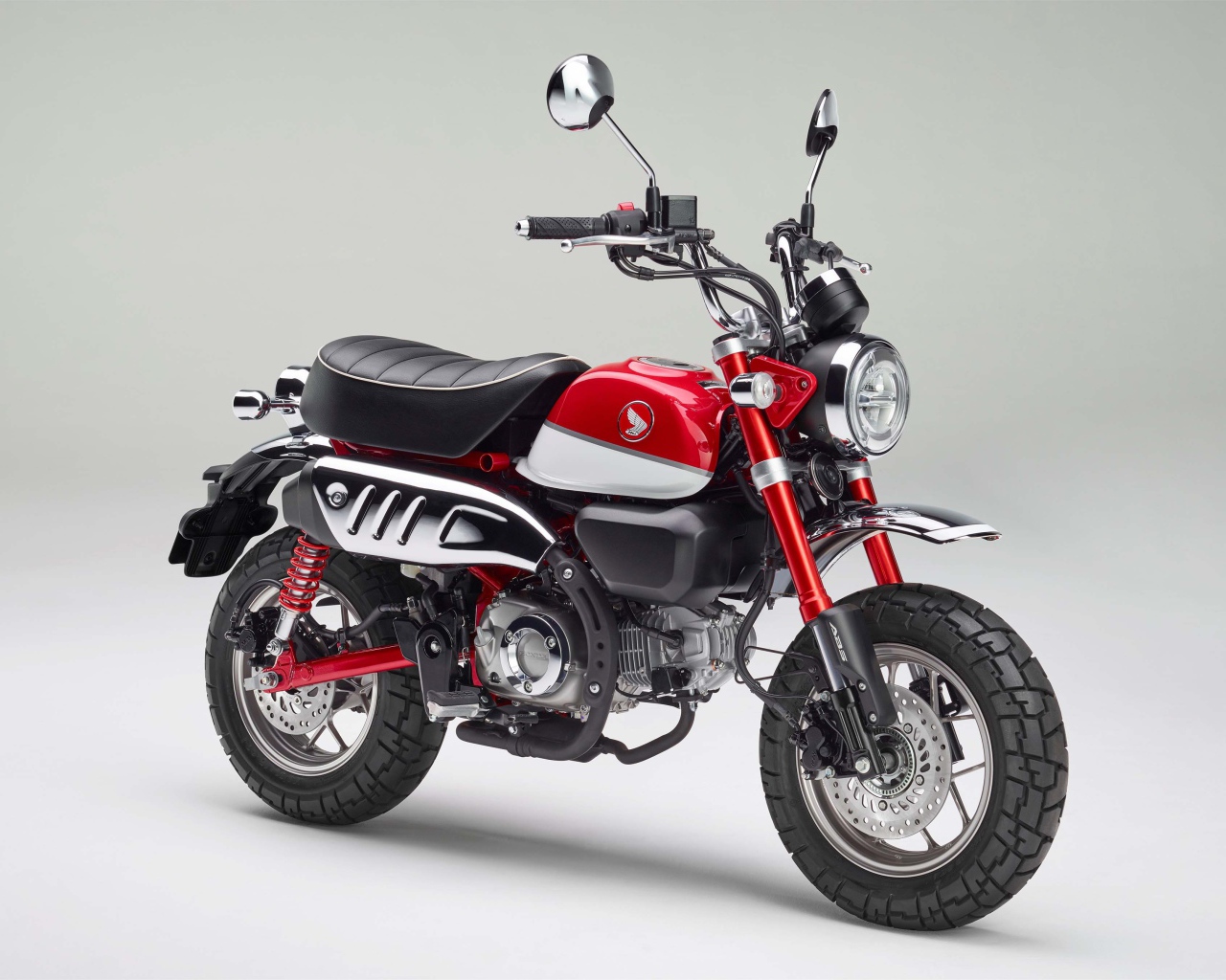 Красный мотоцикл Honda Monkey, 2018 года на сером фоне