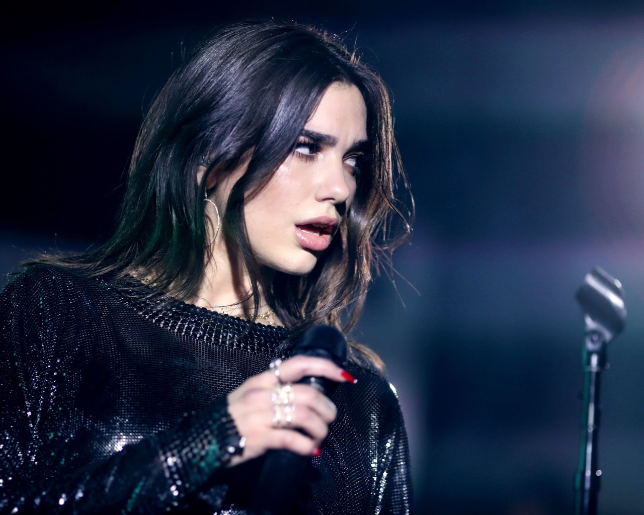 Британская певица Дуа Липа с микрофоном в руках