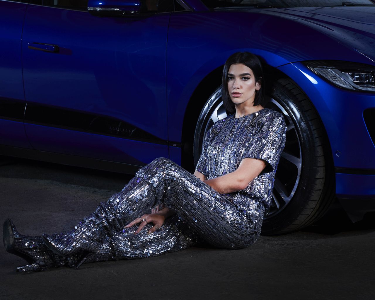 Певица Дуа Липа в блестящем костюме у машины