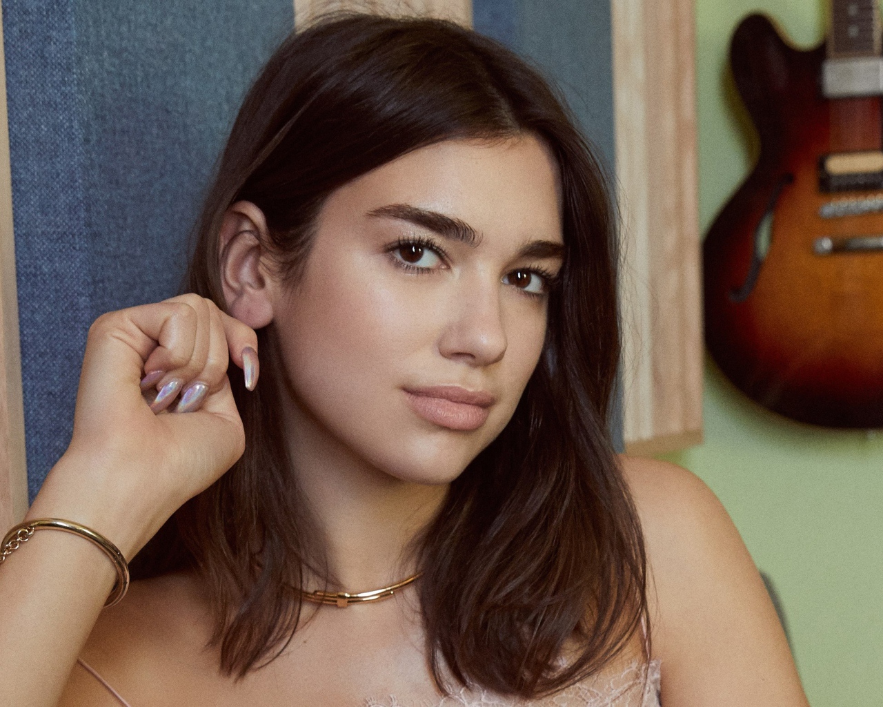 Певица Дуа Липа с гитарой на стене