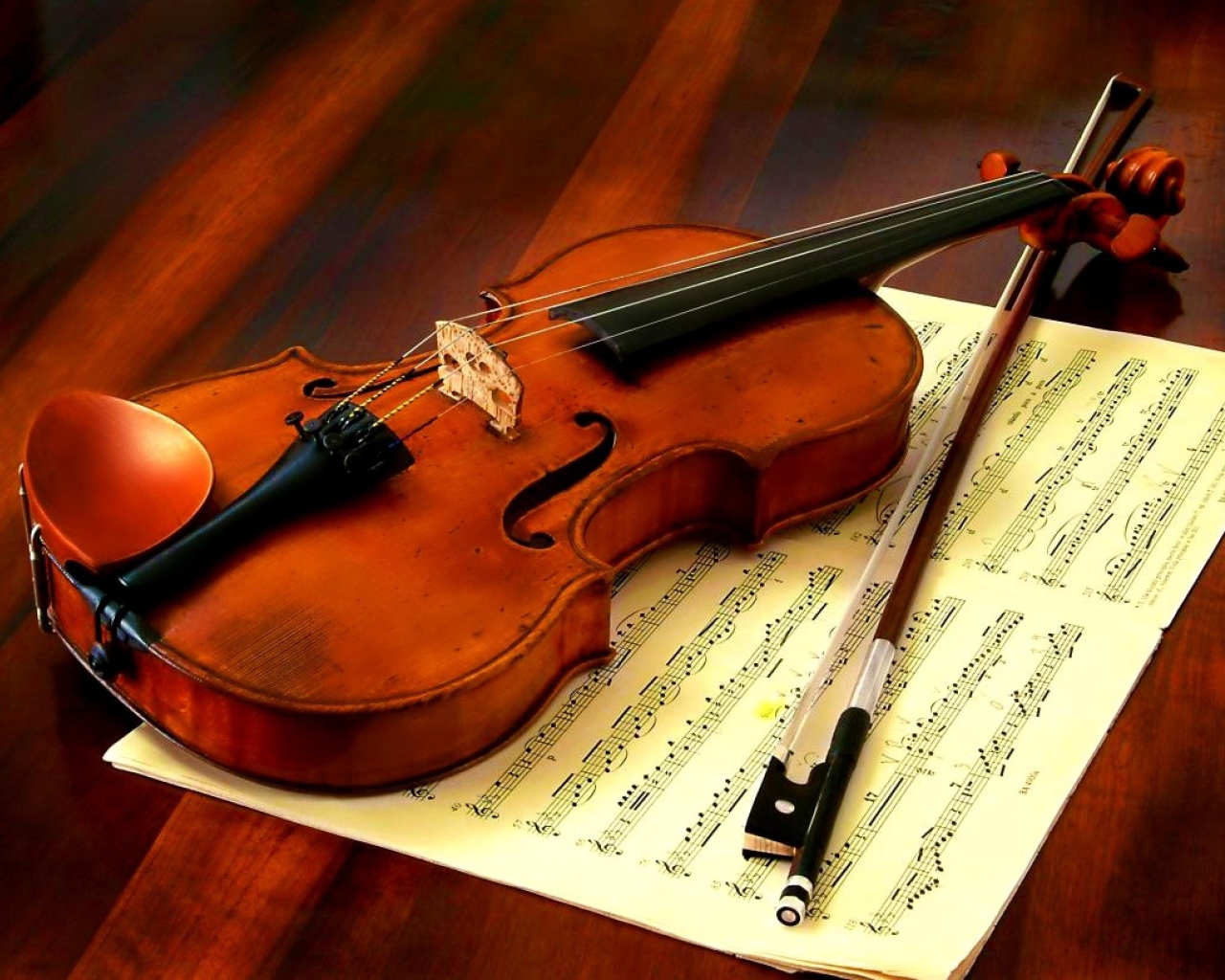 Скрипка со смычком лежат на нотной тетради