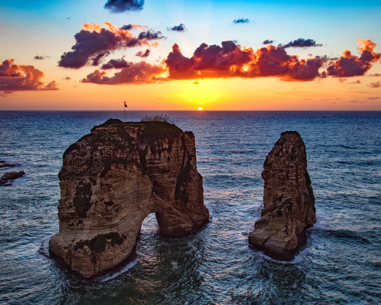 Арка скала в море на закате солнца