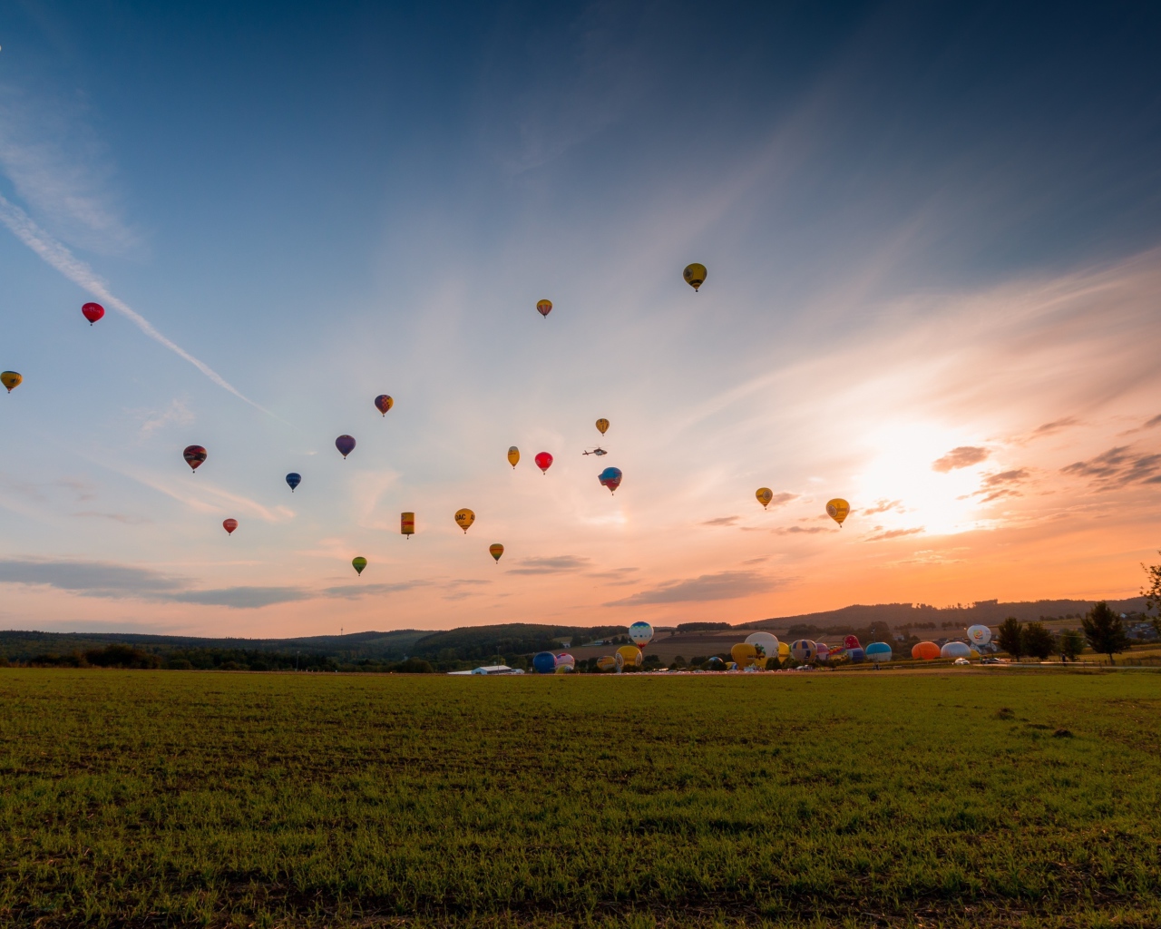 Воздушные шары в небе над зеленым полем