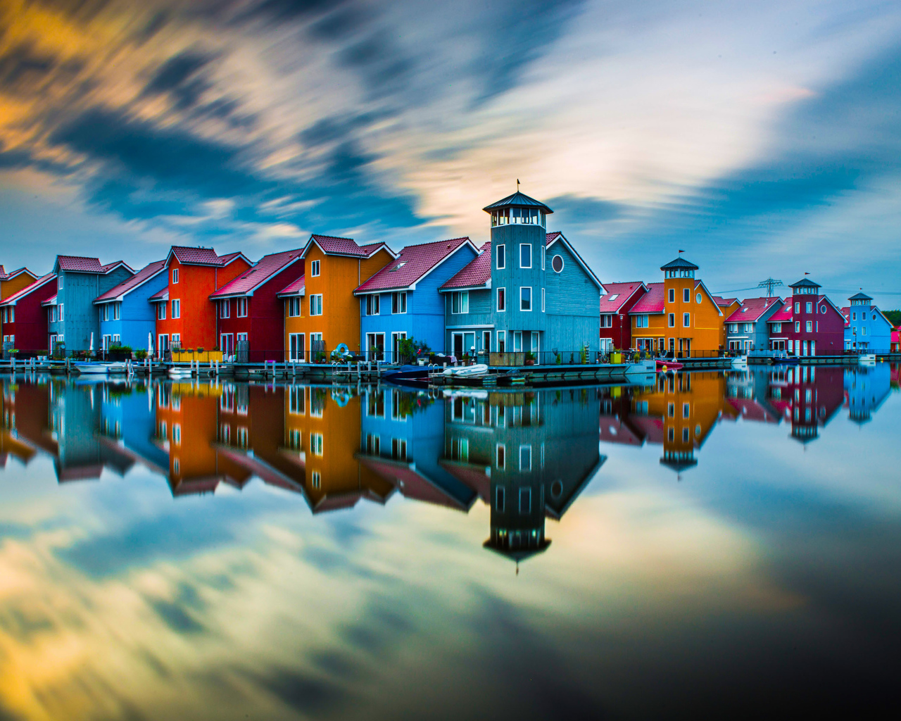 Красивые разноцветные дома отражаются в воде под красивым небом
