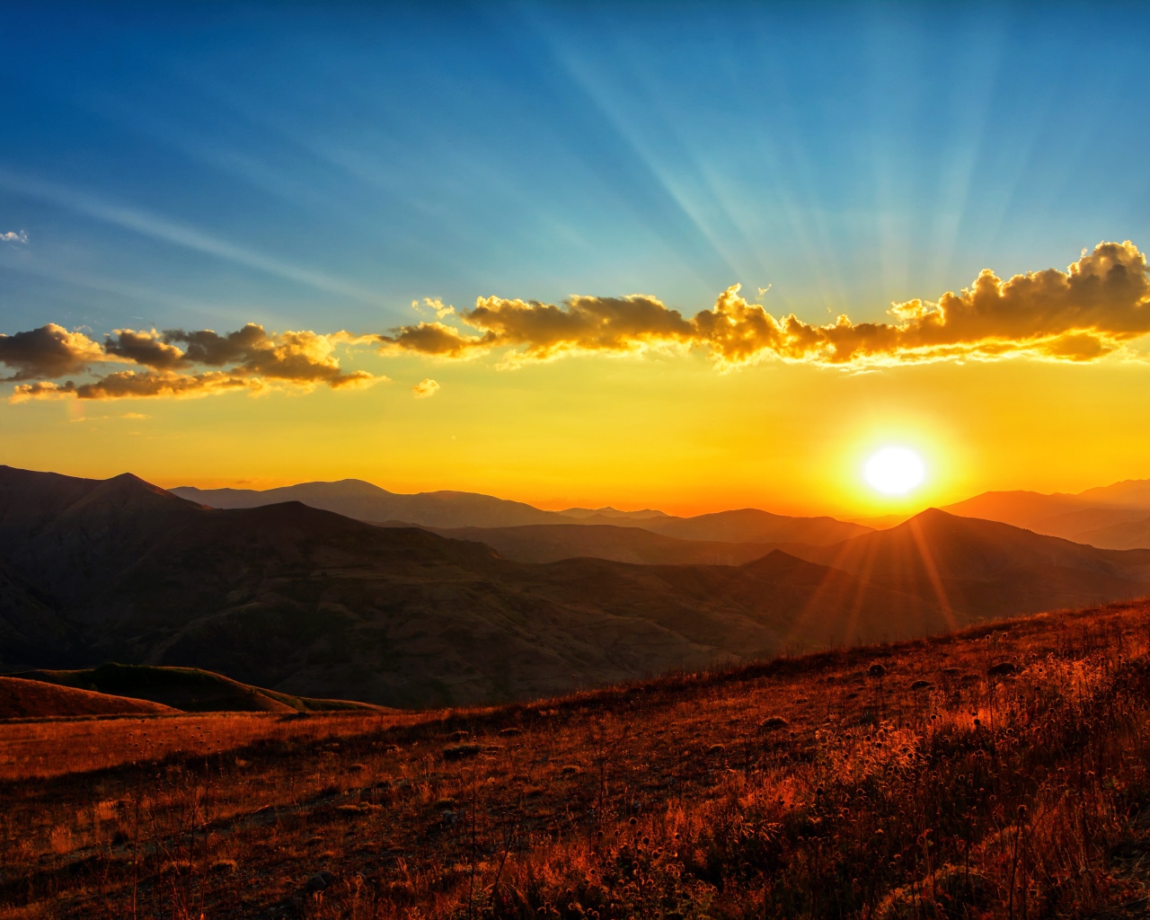 Красивый рассвет в небе над зелеными холмами