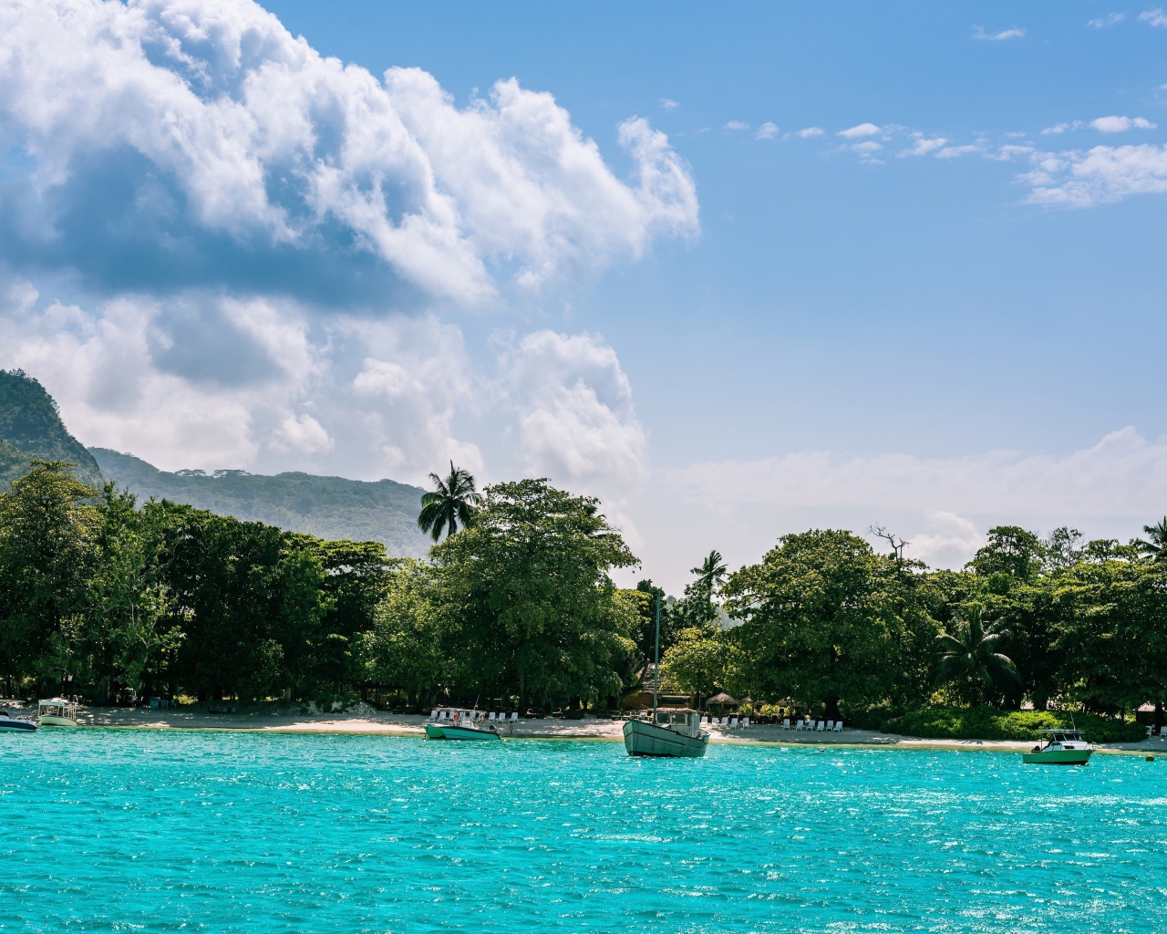 Лодки у берега острова Маэ на Сейшельских островах под красивым небом