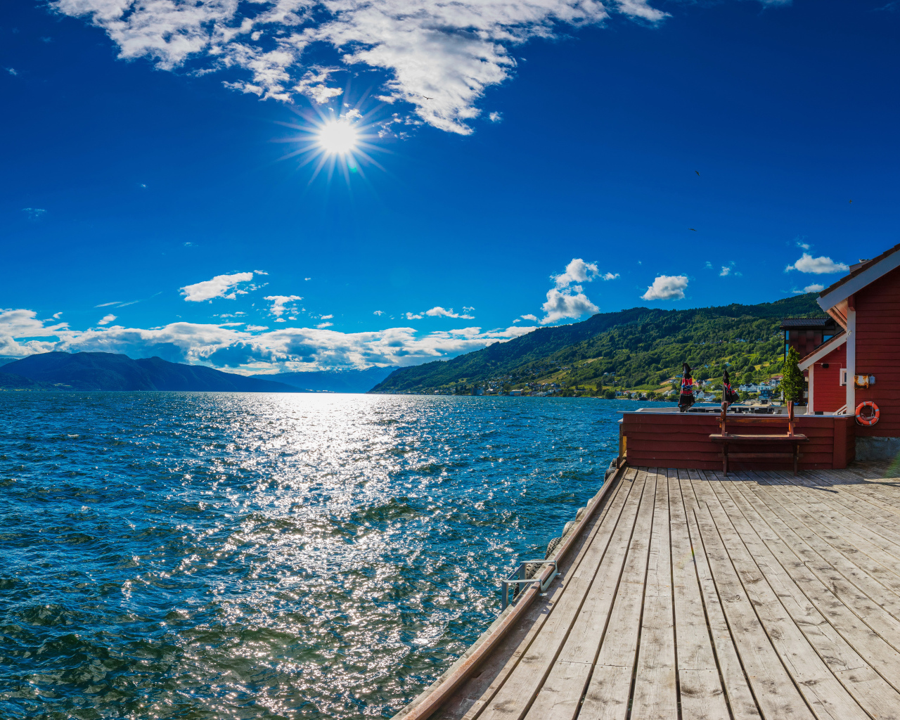 Яркое солнце в голубом небе над водой, Исландия