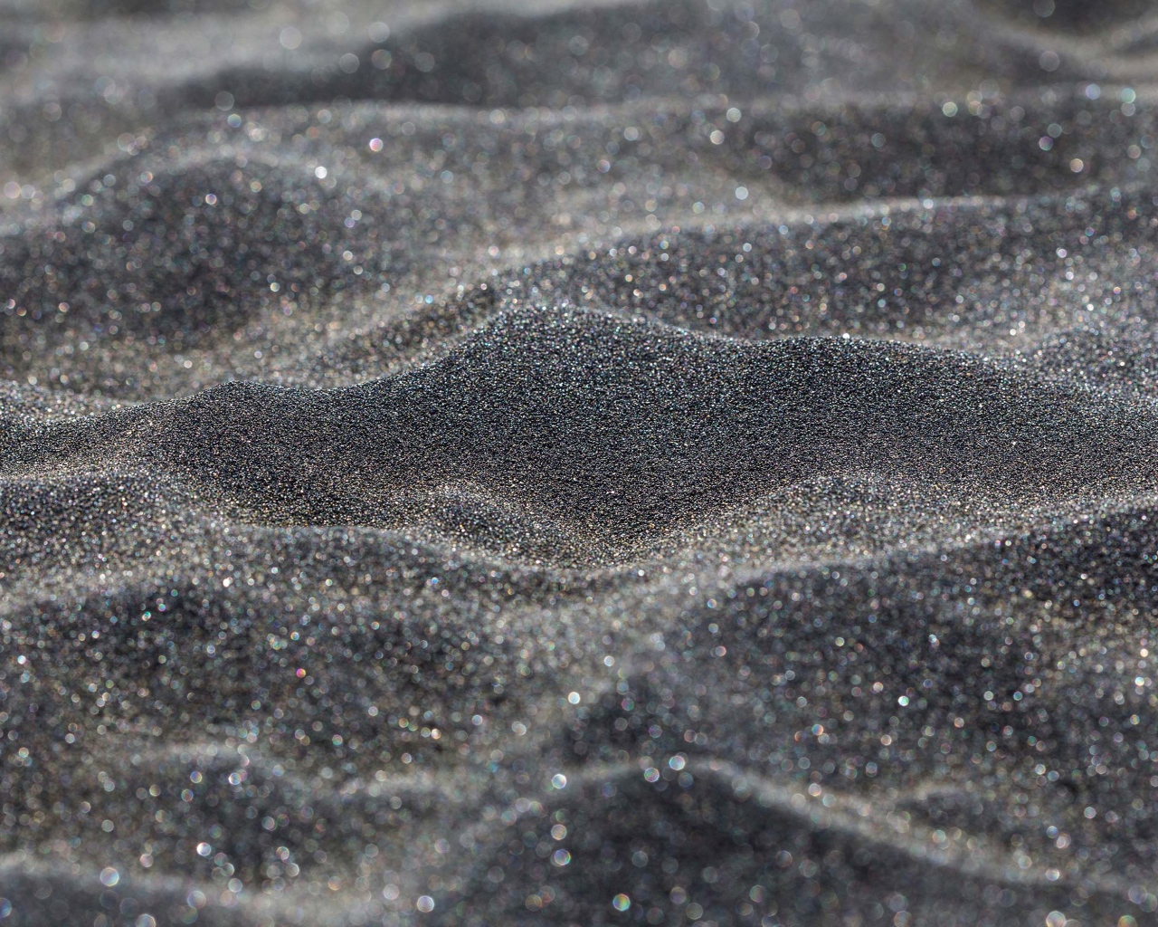 Блестящий черный песок крупным планом
