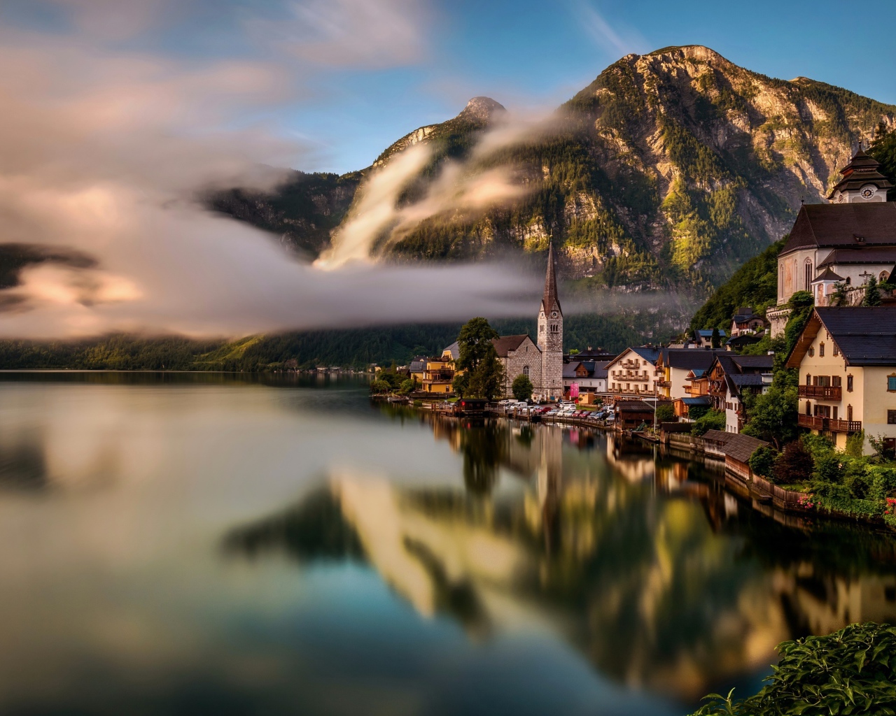Город Гальштат над туманным озером в горах Альпы, Австрия
