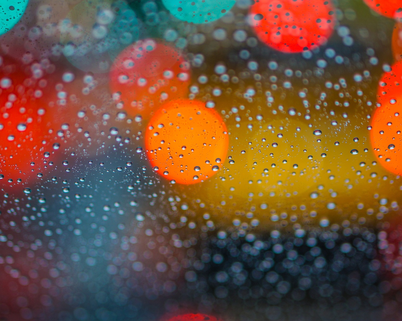 Капли дождя на стекле с разноцветными бликами