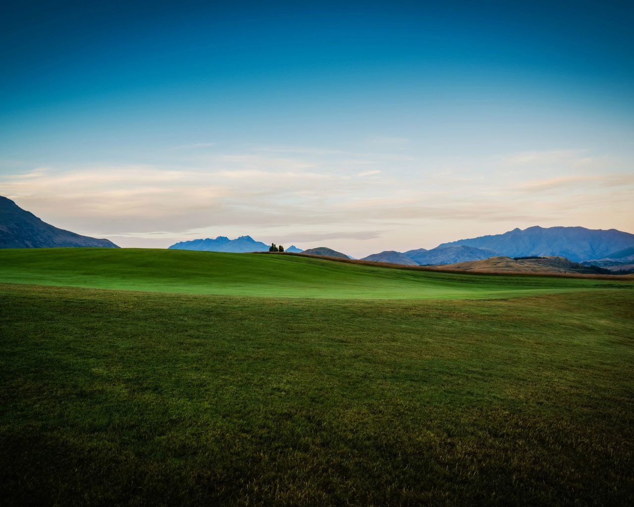 Зеленый луг на фоне красивого неба