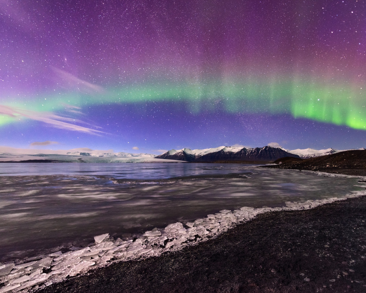 Северное сияние в небе над покрытым льдом озером 