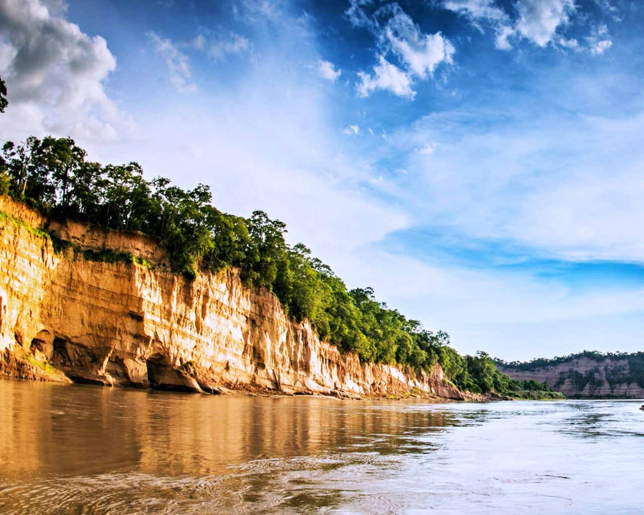 Скала на берегу реки под красивым небом