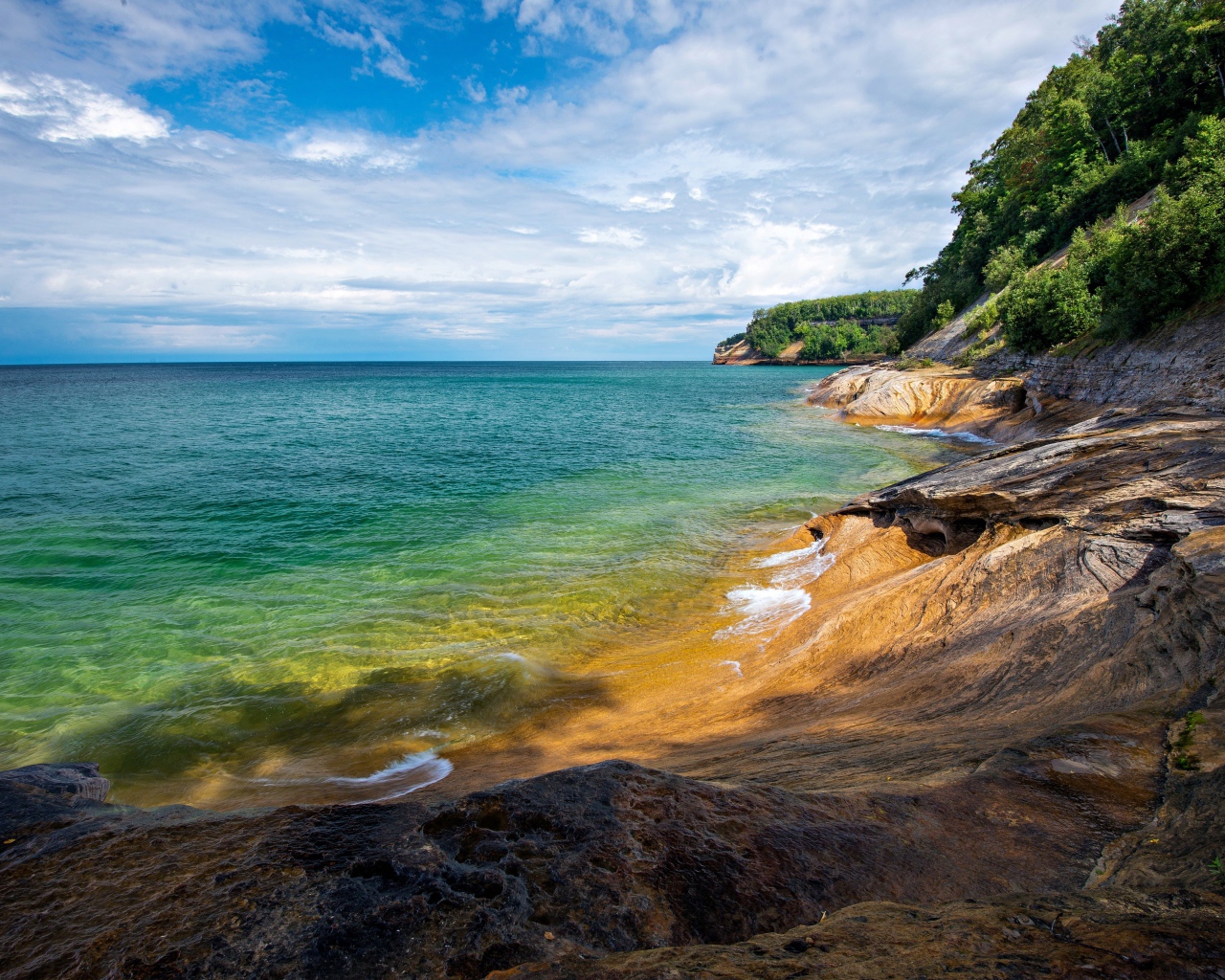 Скалистый берег у голубой воды моря на фоне неба