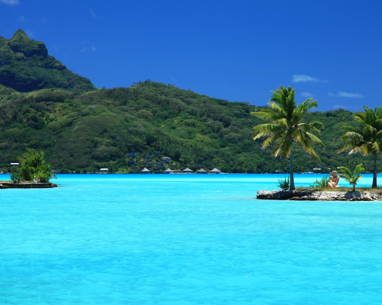 Small islets with palm trees in the blue ocean