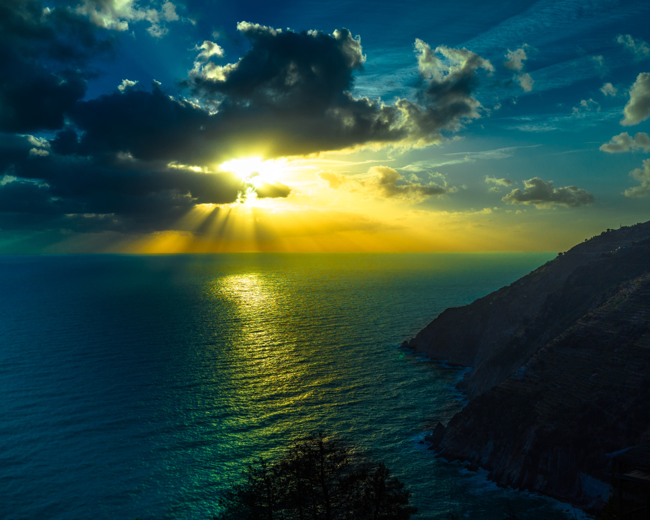 Лучи солнца пробиваются сквозь облака над океаном