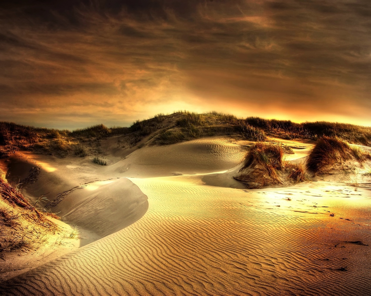 Волнистый песок под красивым небом на закате