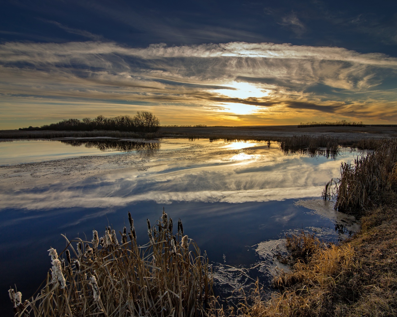 Белые облака отражаются в воде на закате солнца