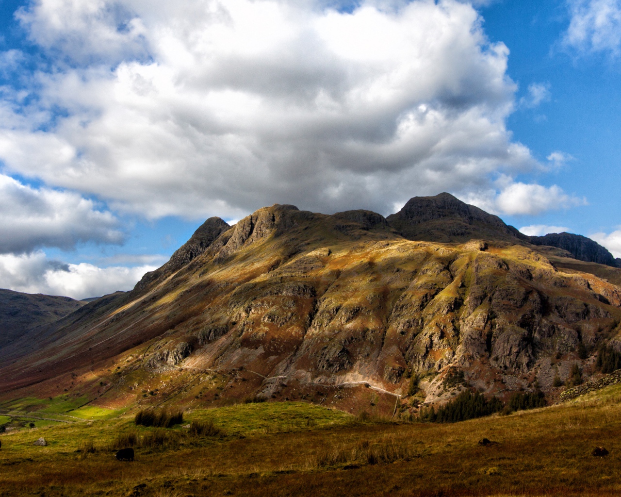 Белые пушистые облака над горой 
