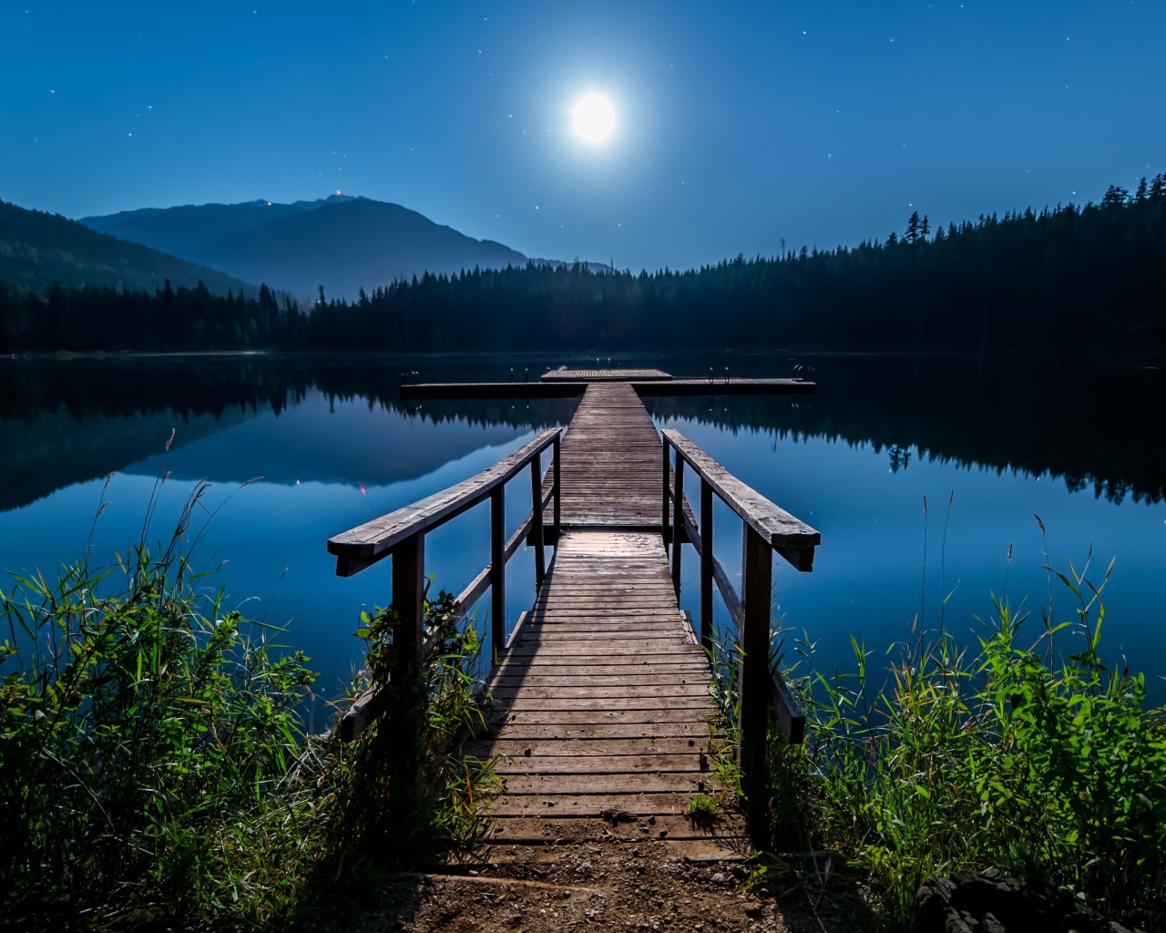 Деревянный мост на озере в полнолуние