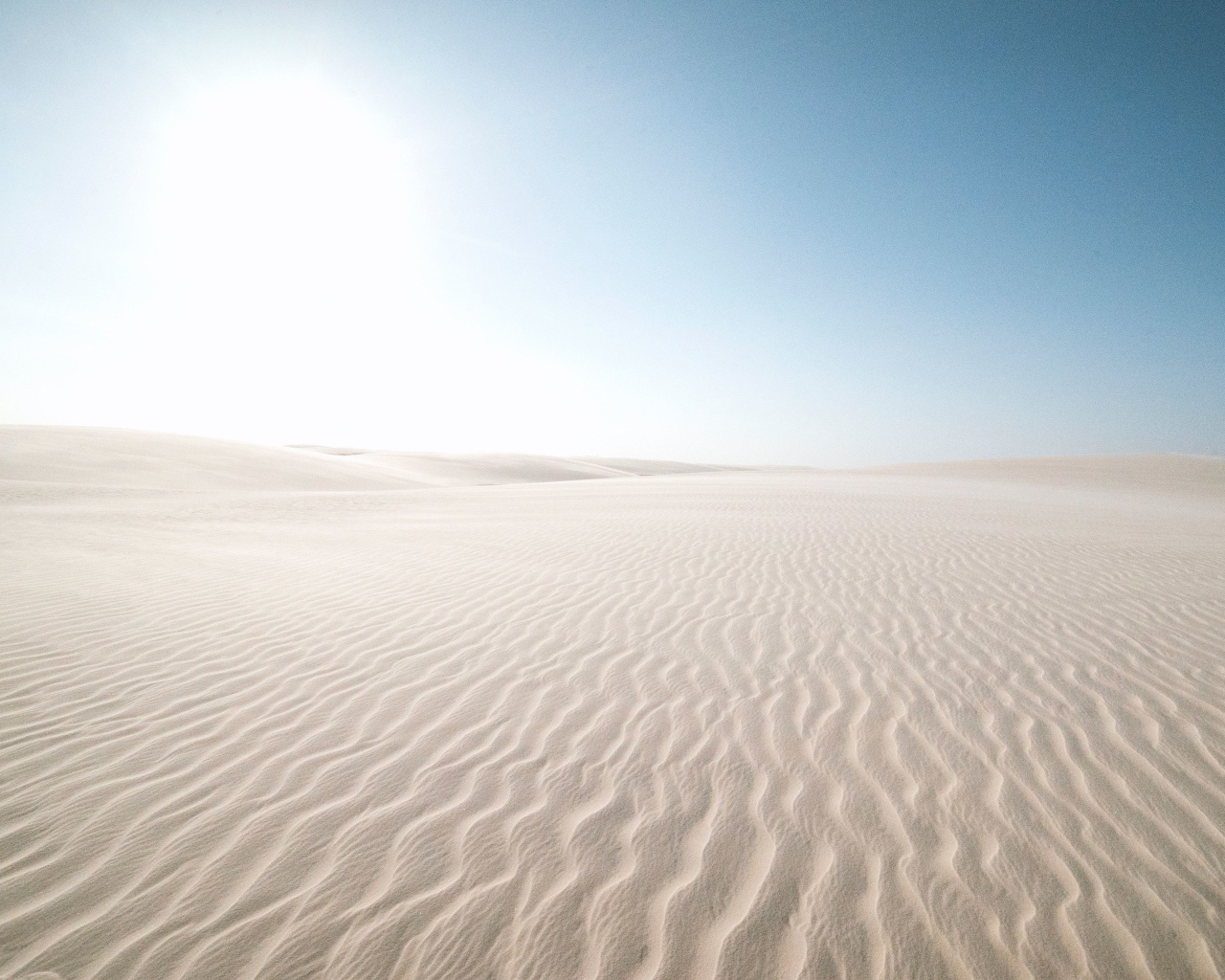 Белый песок в пустыне на фоне голубого неба