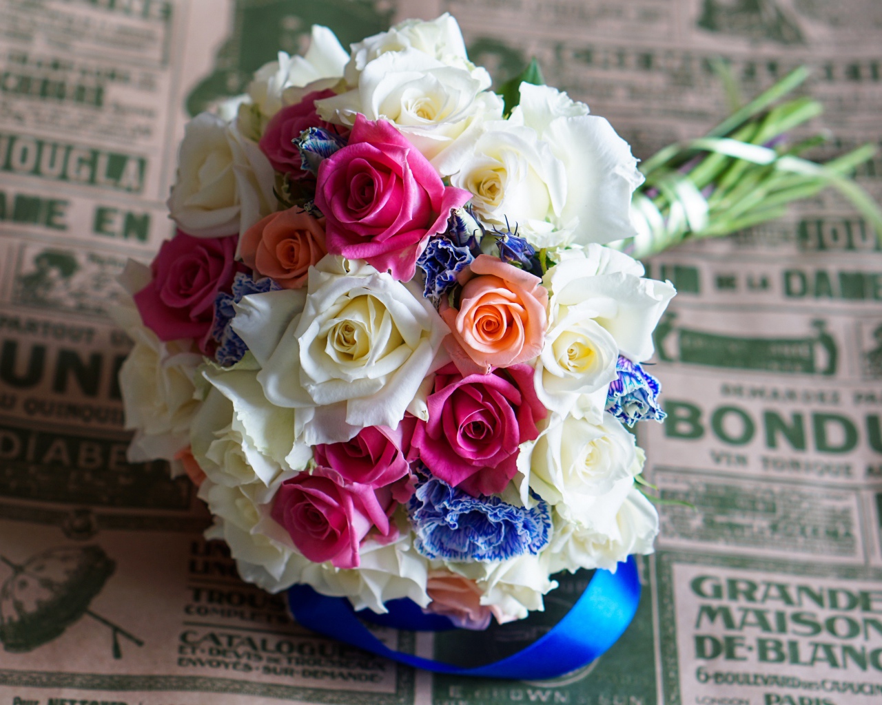 Красивый свадебный букет из роз лежит на газете