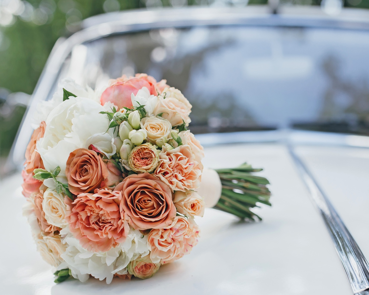 Свадебный букет роз лежит на машине