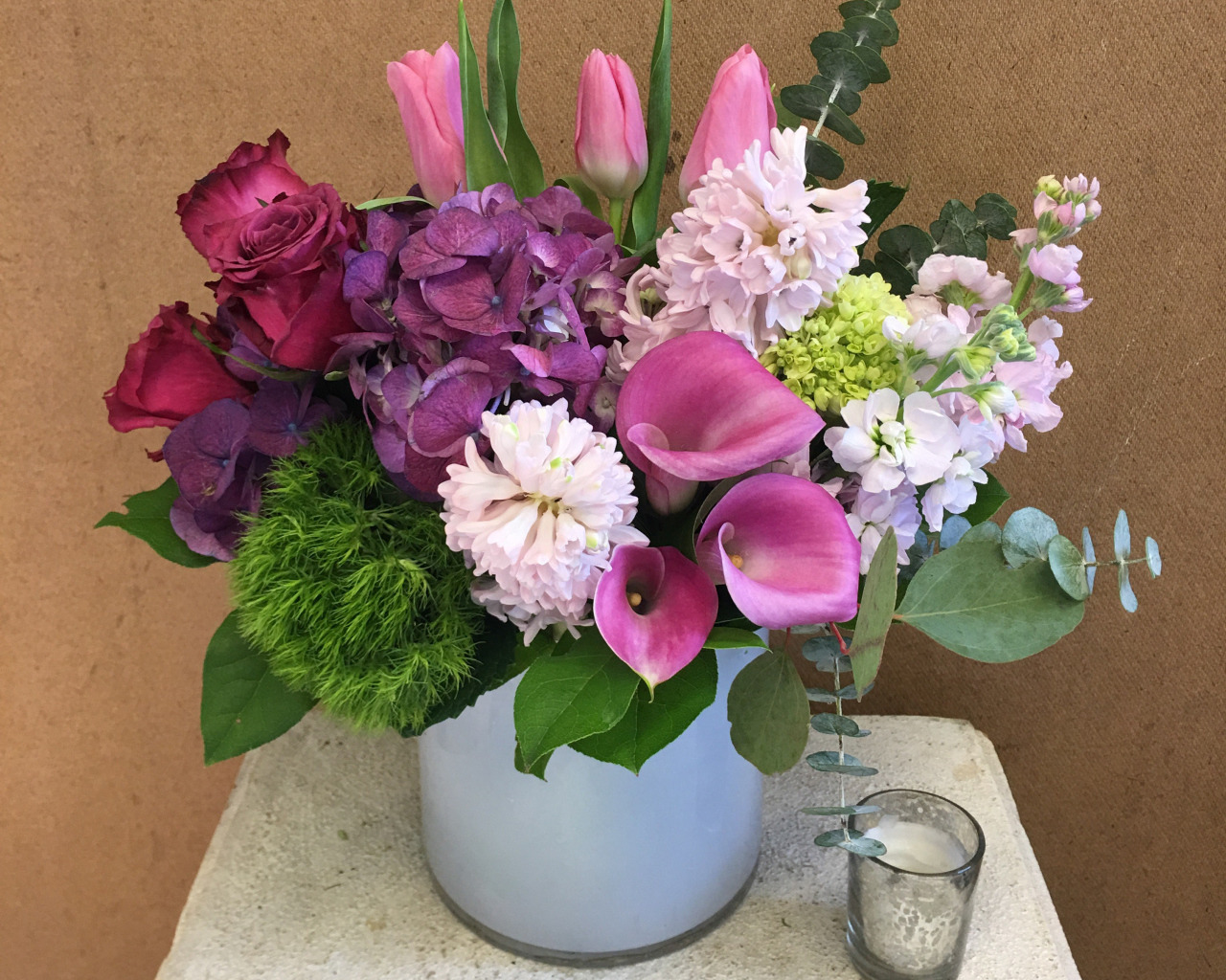 Красивый букет цветов в вазе у стены