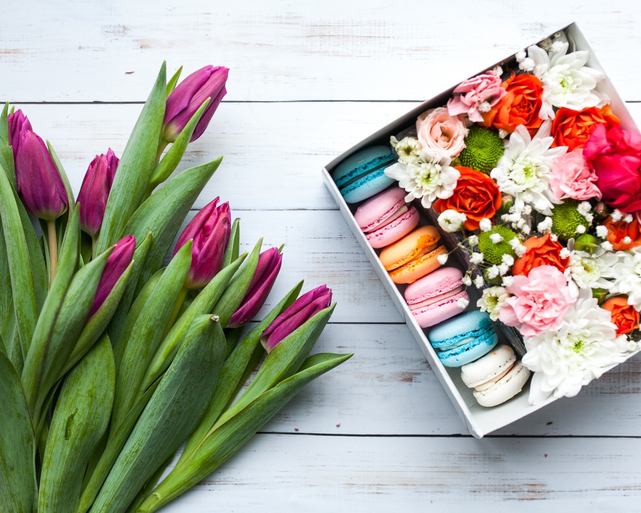 Букет сиреневых тюльпанов на столе с коробкой с макарунами