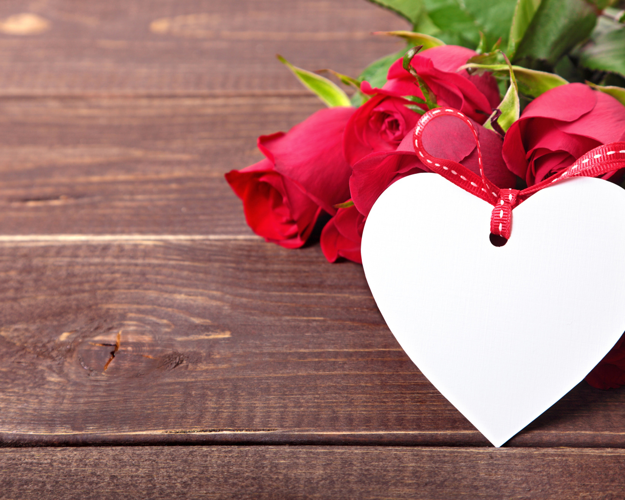 Букет розовых роз с бумажным сердцем на деревянном фоне