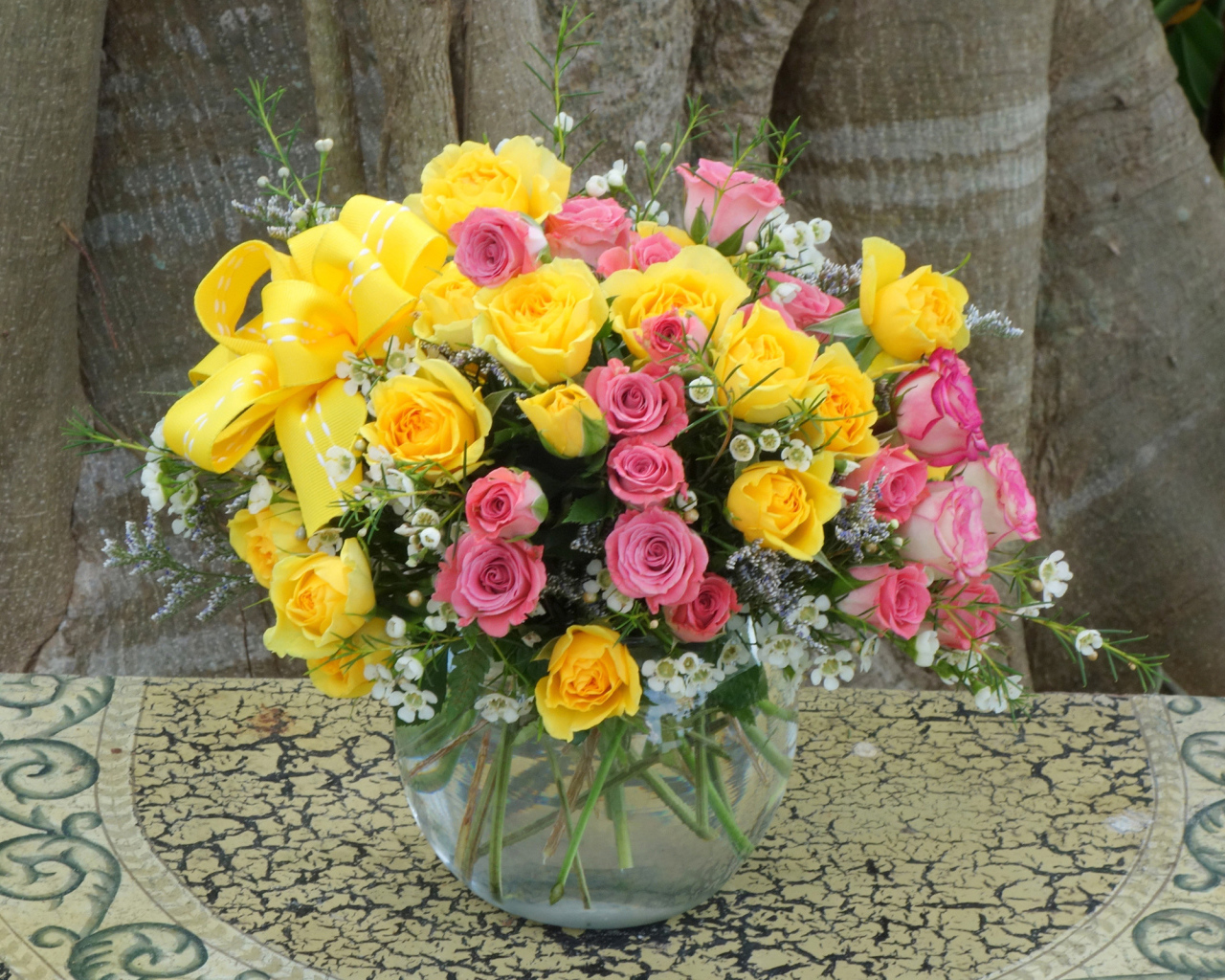 Букет желтых и розовых роз в стеклянной вазе