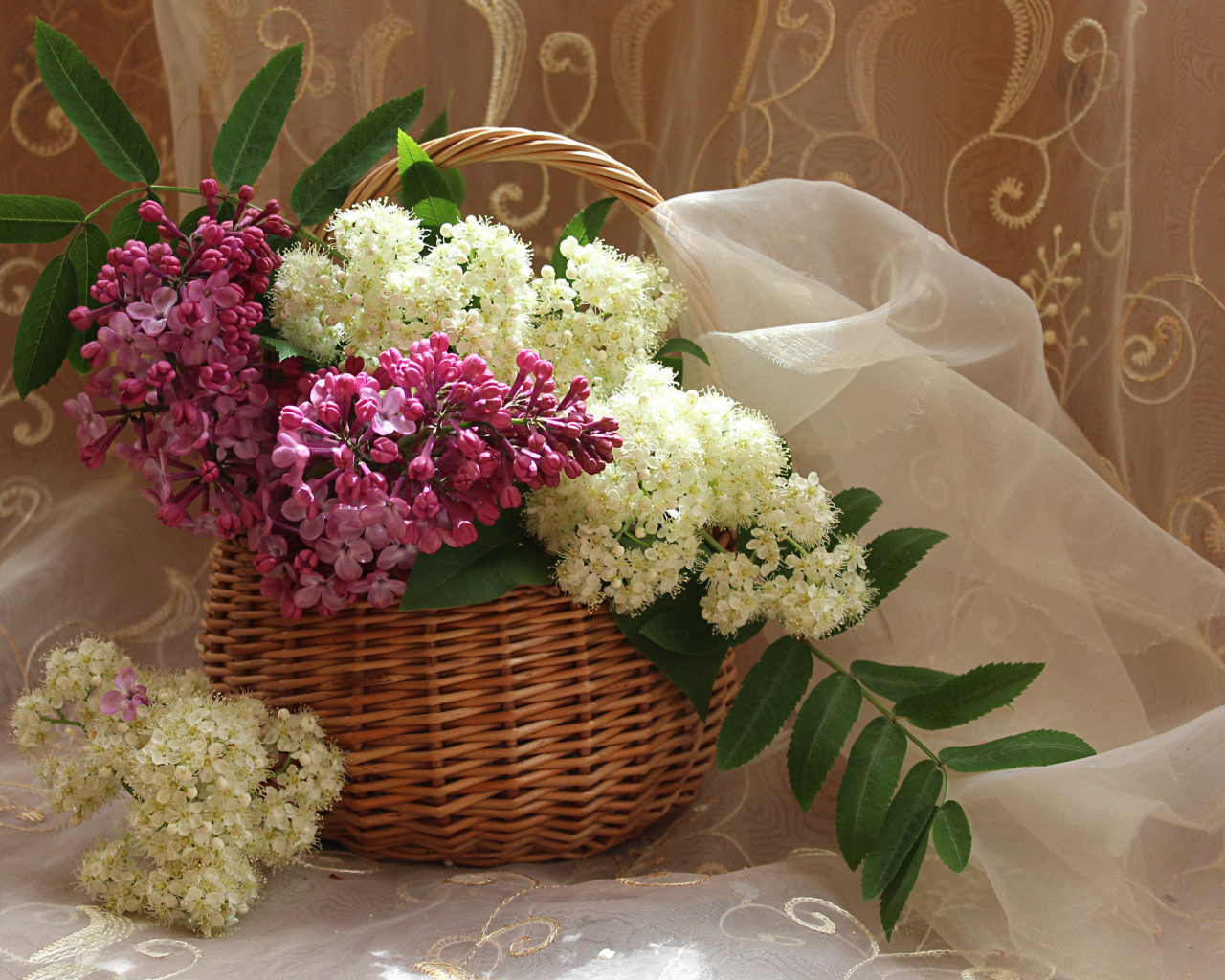Ветки сирени и белой цветущей рябины в корзине
