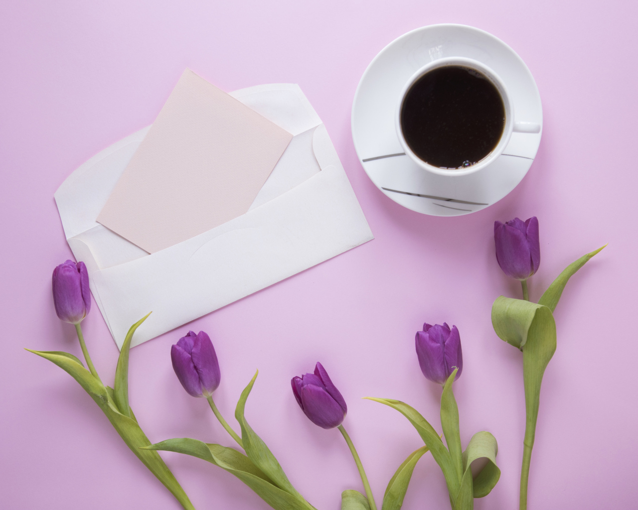 Сиреневые тюльпаны с письмом и чашкой кофе на столе 