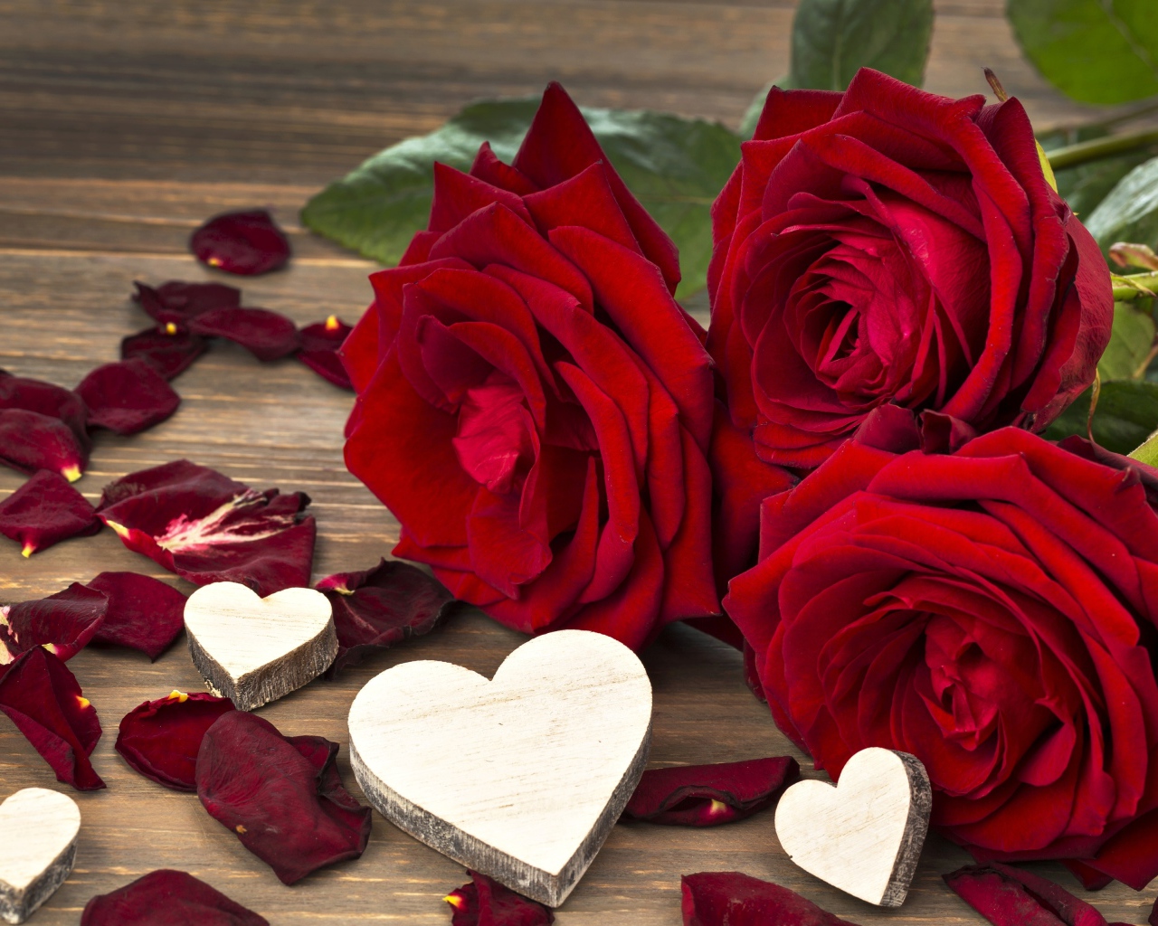 Три крупные красные розы с деревянными сердечками
