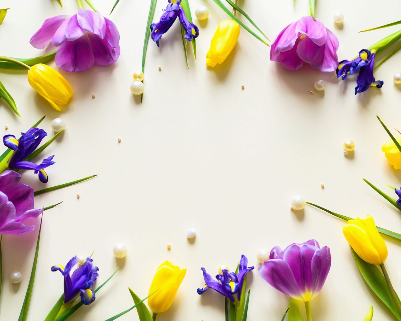 Тюльпаны  и ирисы с жемчужинами на столе 