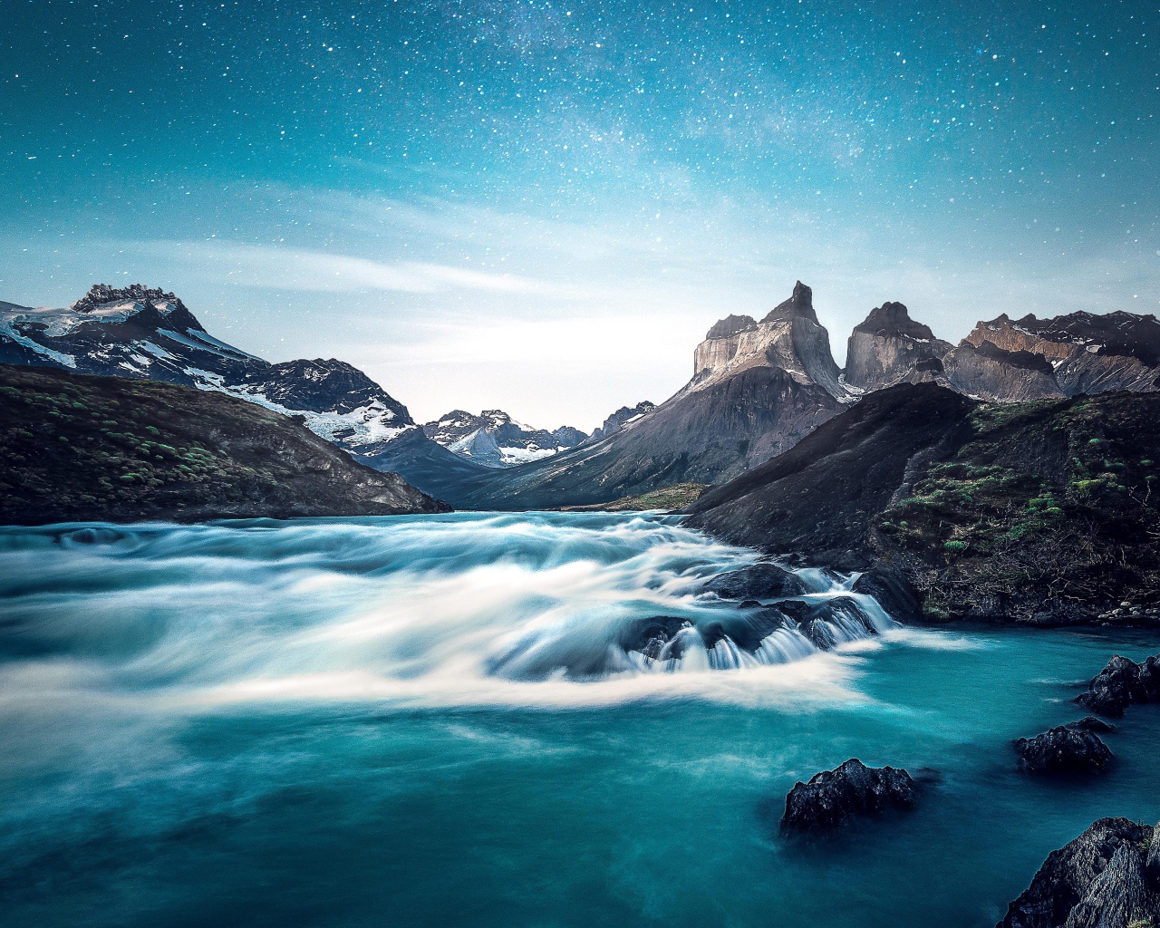 Быстрая вода к реке у гор на фоне голубого неба 