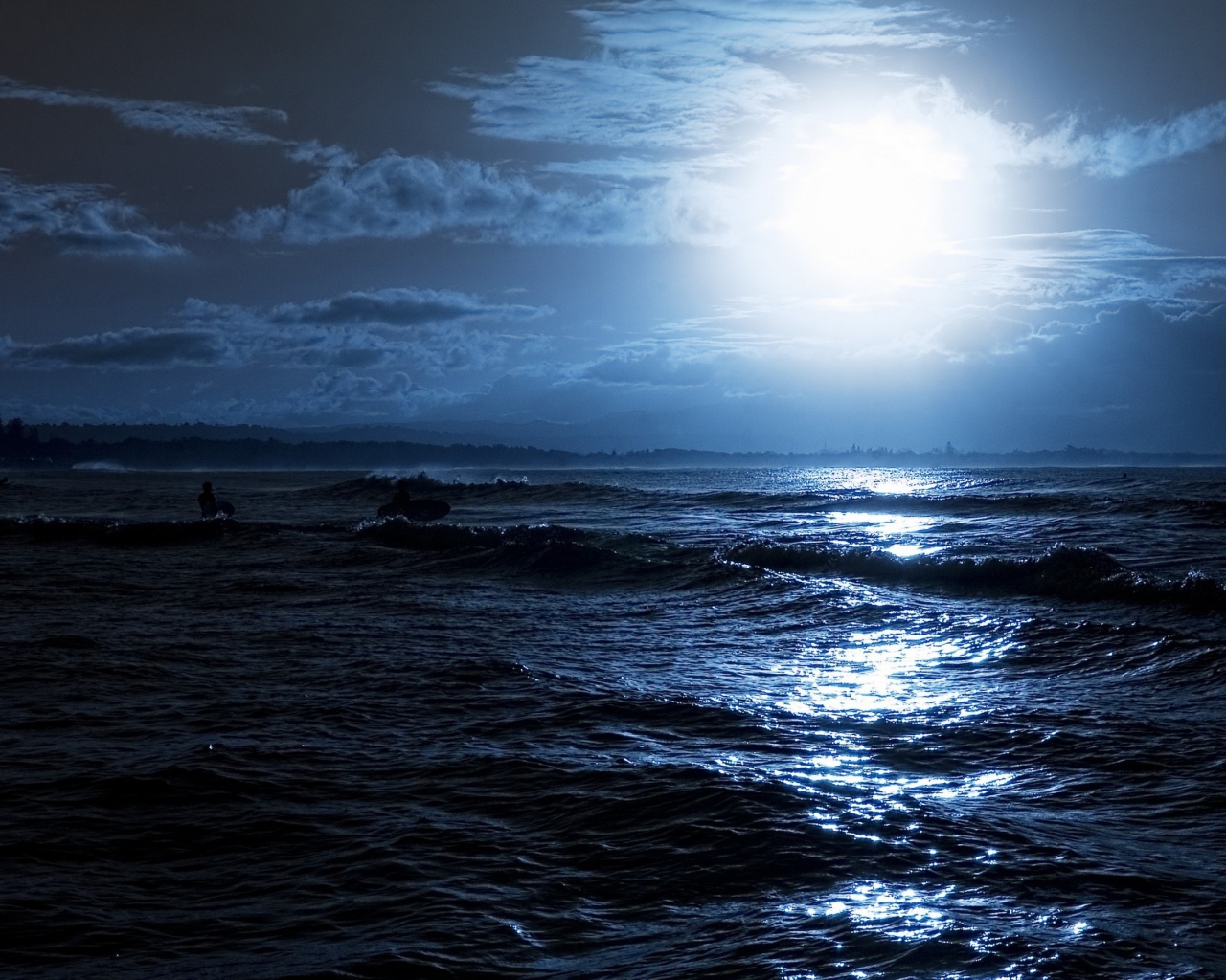 Яркая луна освещает волны на берегу моря