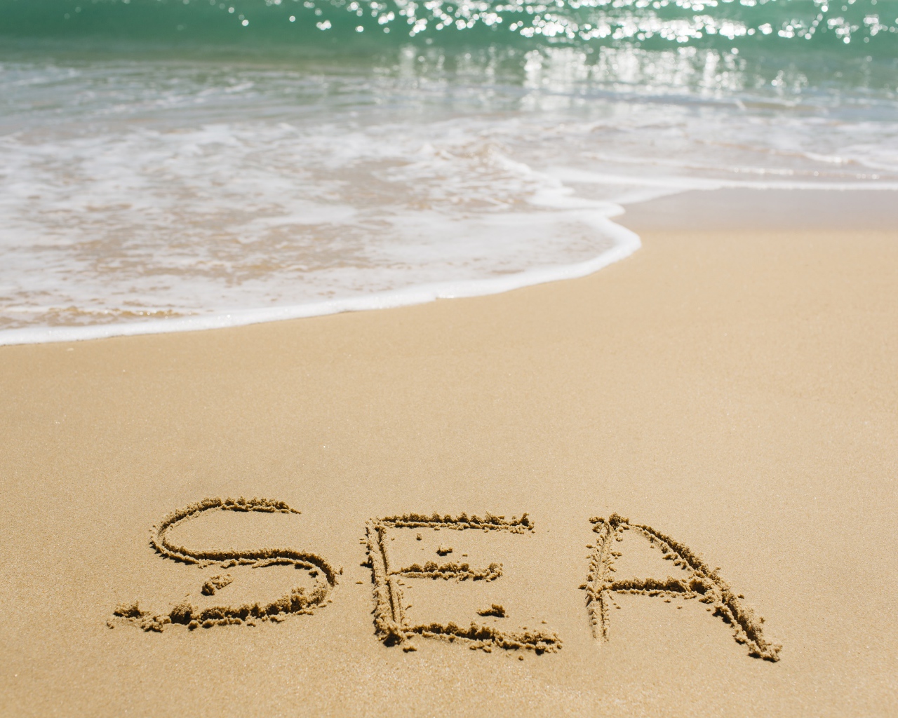 Надпись на песке у моря летом