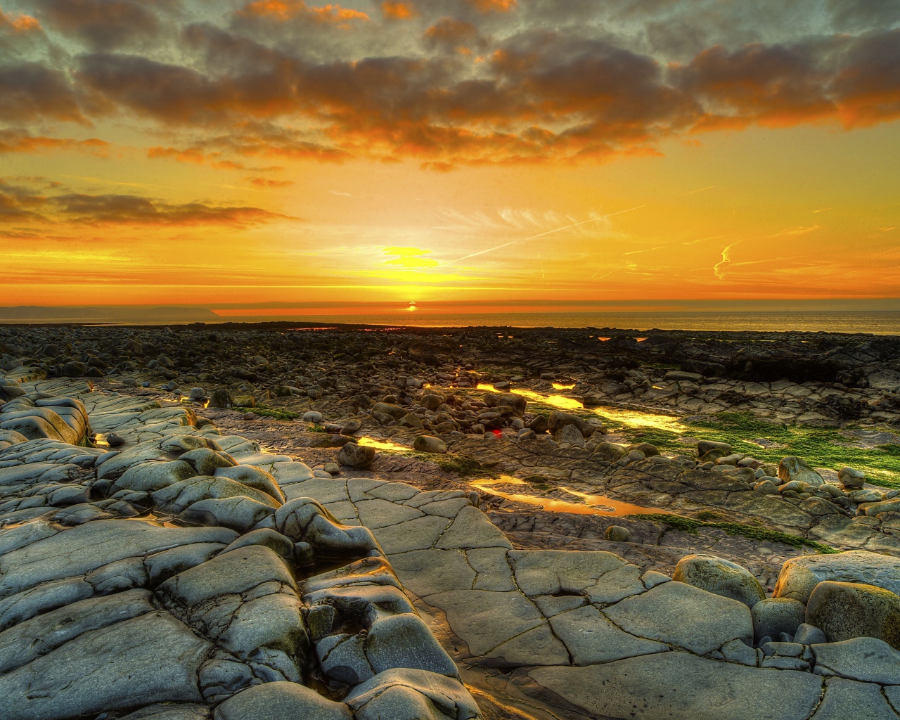 Каменный берег на фоне красивого неба на закате солнца
