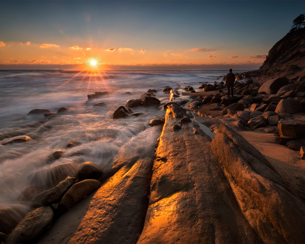 Каменный берег на морском побережье на закате солнца