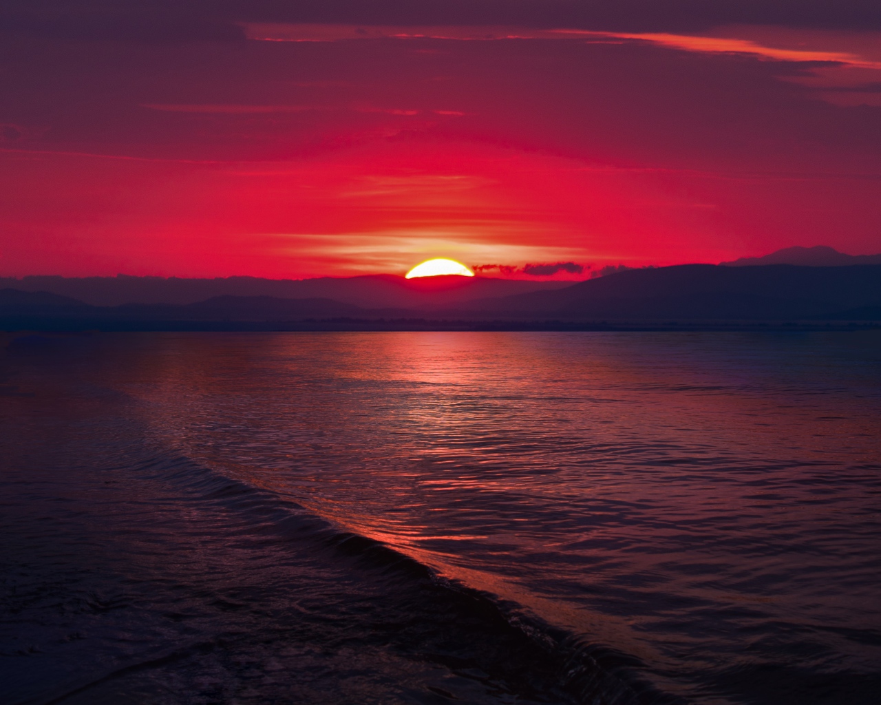 Закат красного солнца на морском горизонте 