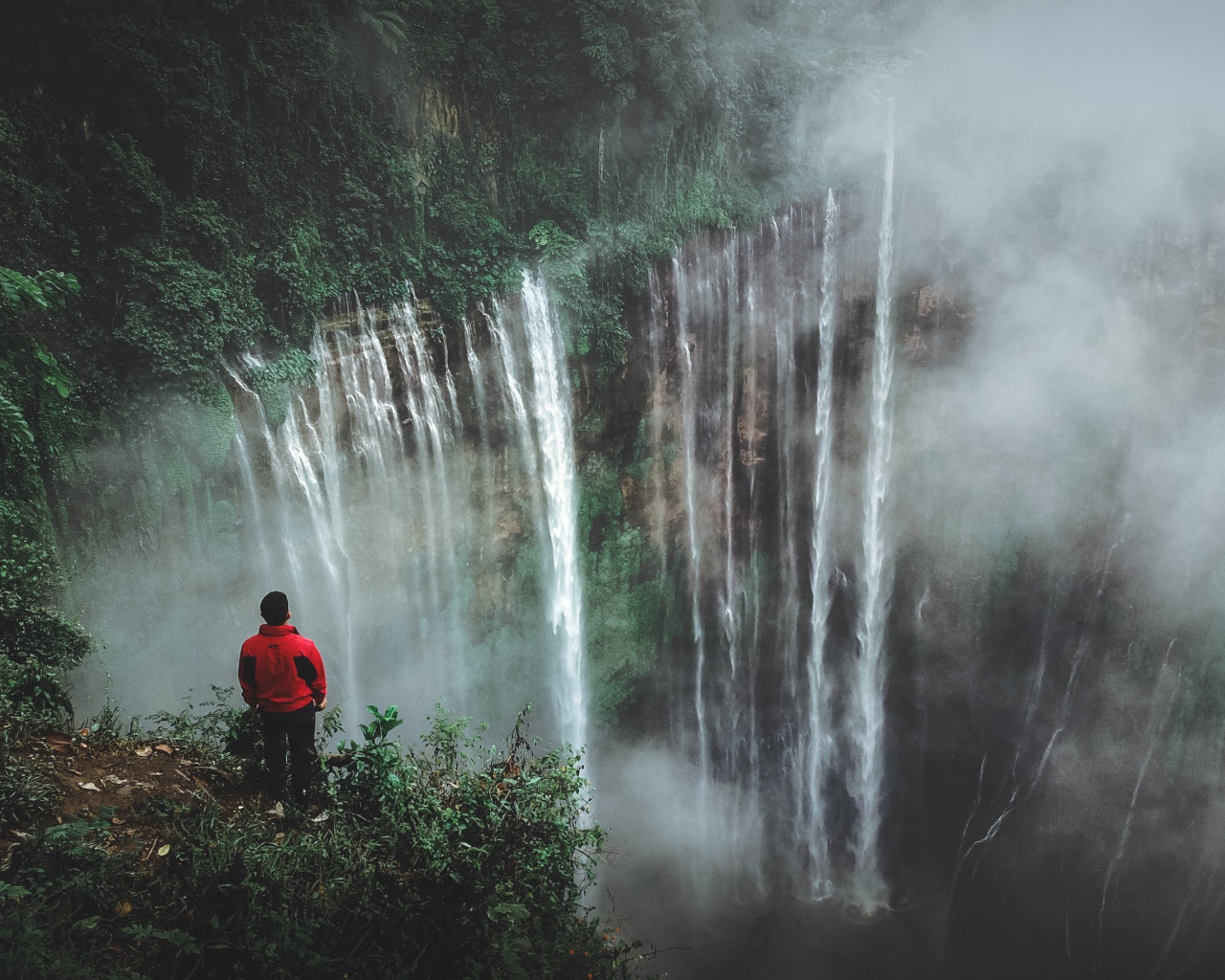 Человек смотрит на водопад сверху. 