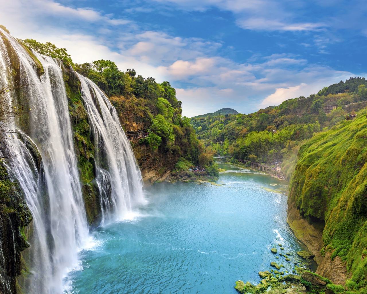 Красивый водопад стекает с утеса под голубым небом