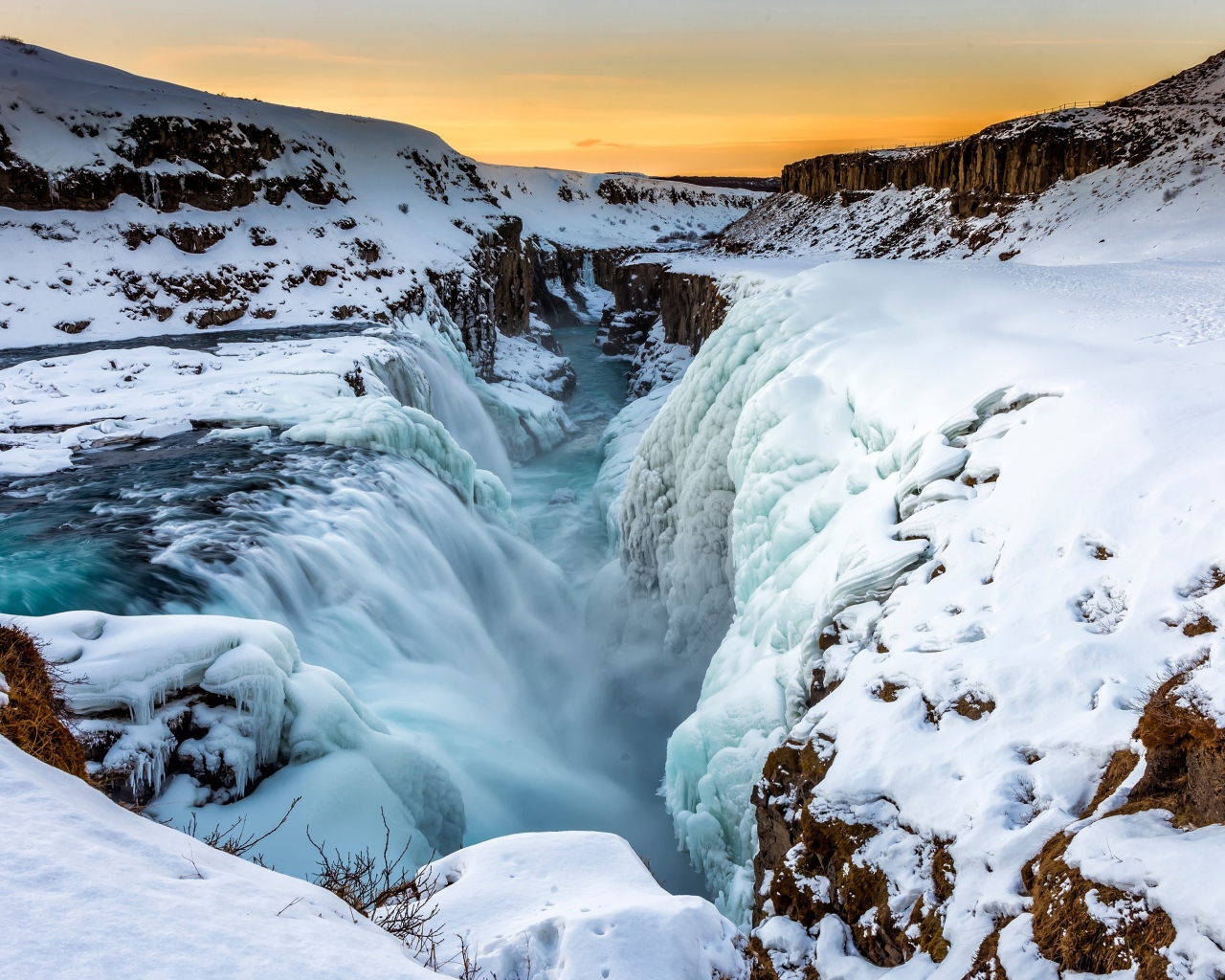 Заледеневший водопад у покрытых снегом берегов, Исландия
