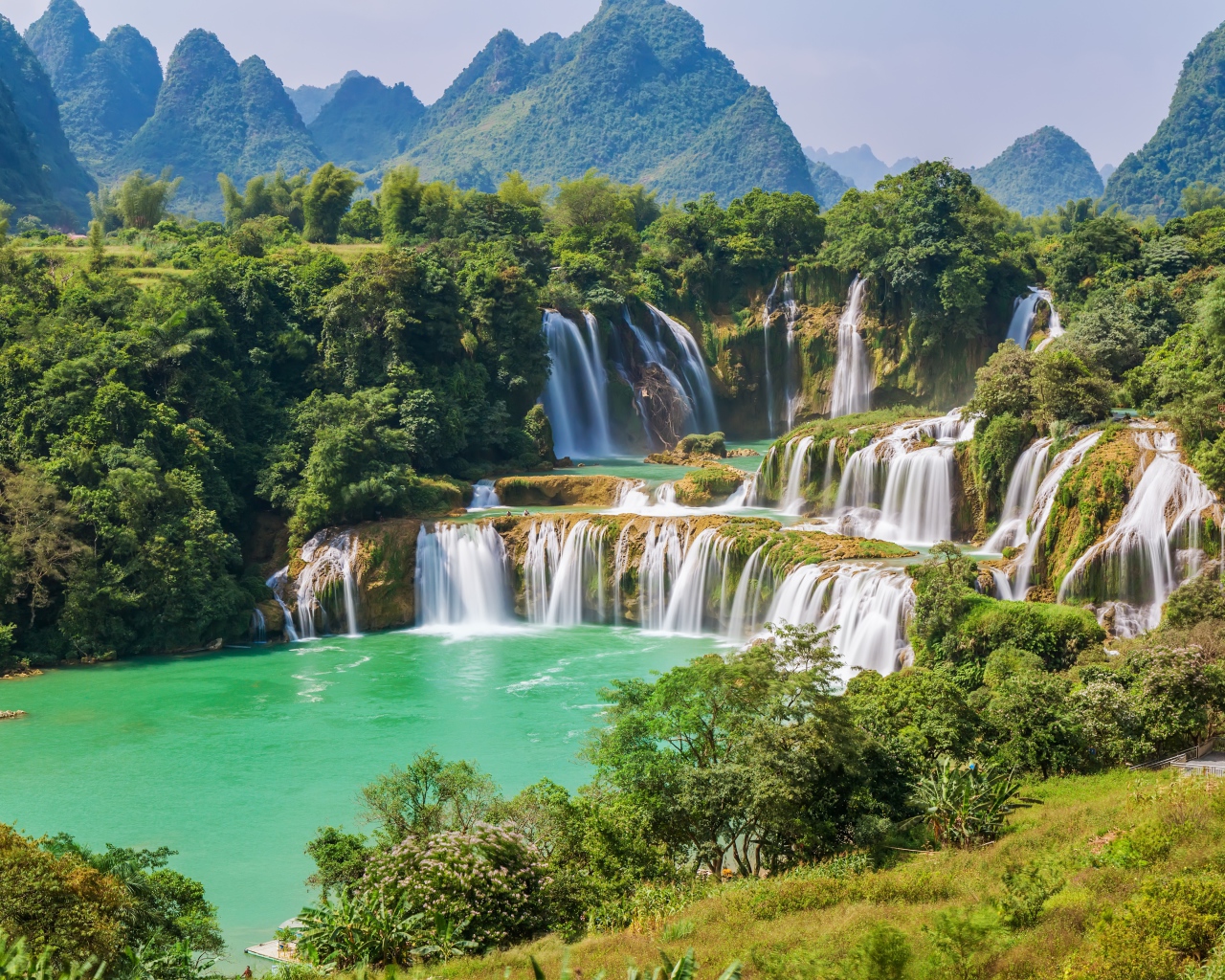 Водопад стекает с гор на фоне зеленой природы