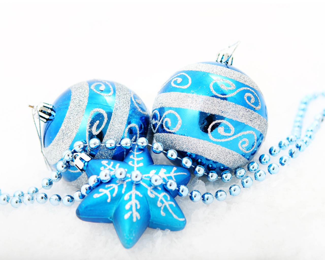 Красивые голубые елочные шарики со звездой и бусами на белом фоне